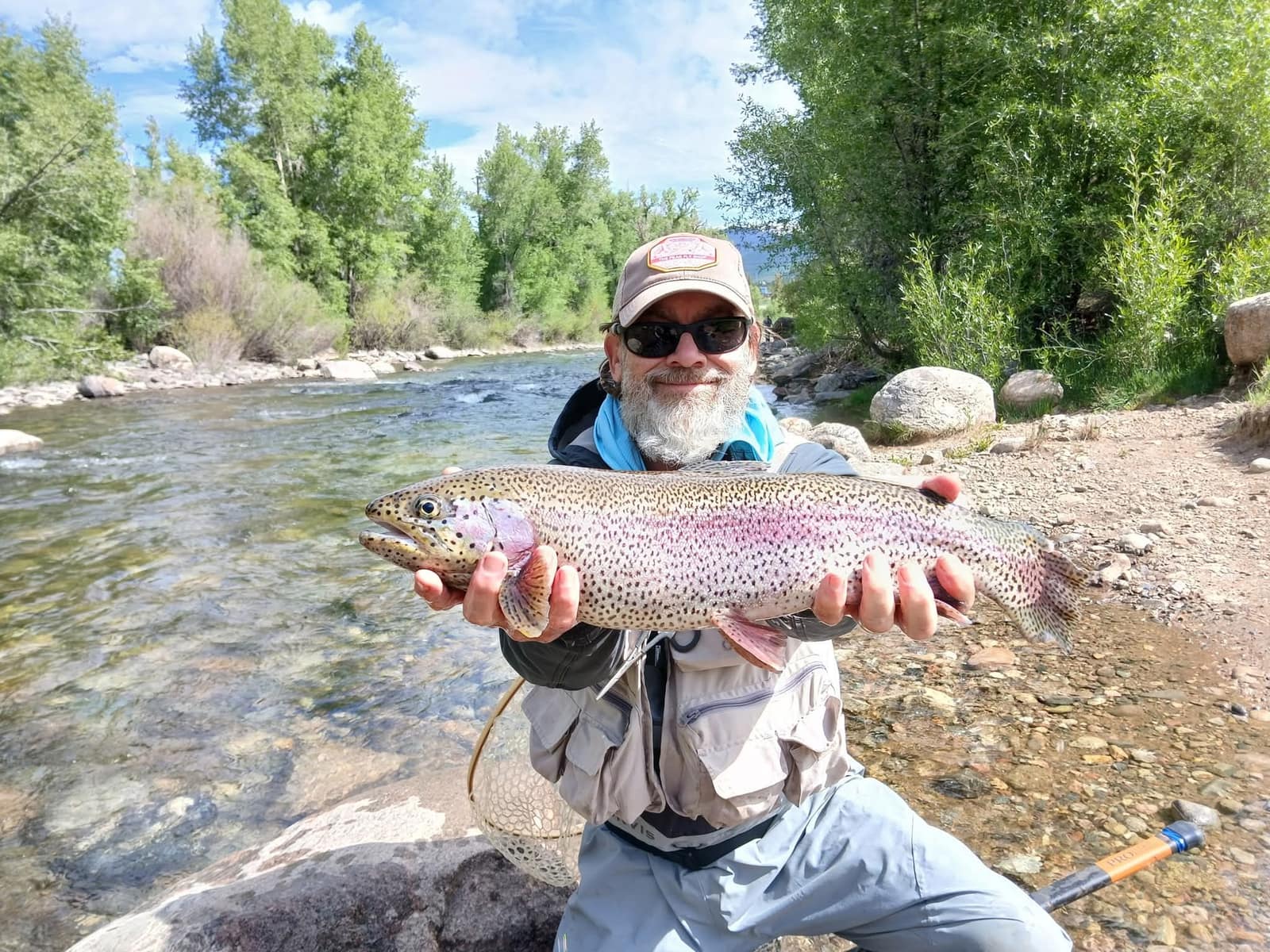 Angler holding a large rainbow trout on a Colorado river