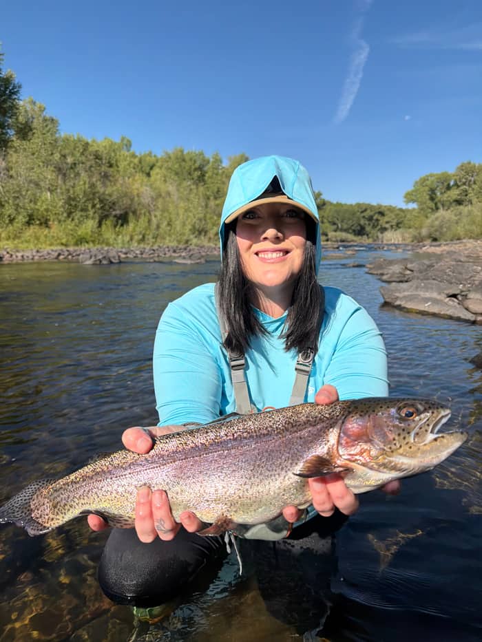 Angler holding a rainbow trout in the river