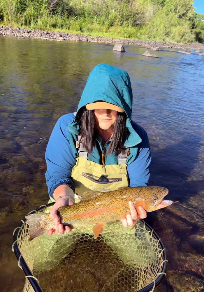 Angler cradling a rainbow trout above the net