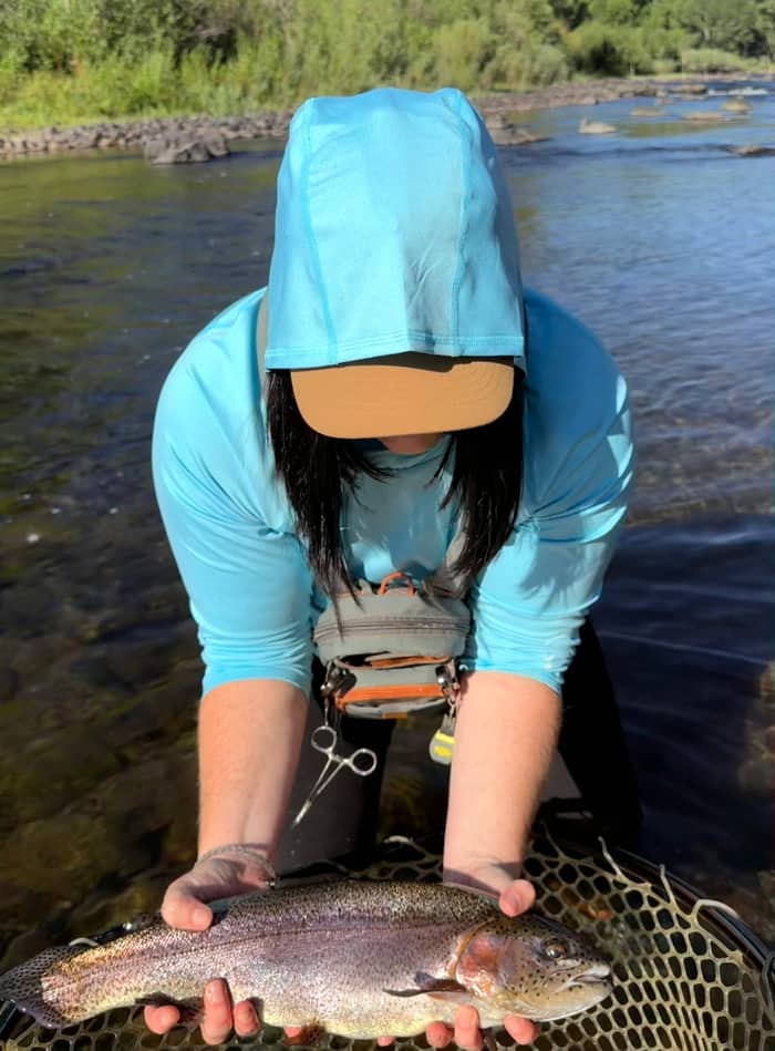 Angler releasing a rainbow trout back into the river