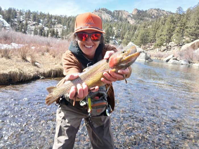 Angler holding a cutthroat trout on a cold-weather river
