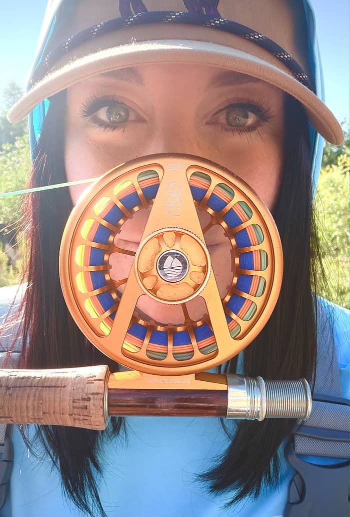 Fly reel and cork rod handle held up on the water